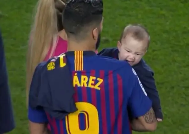 Lauti biting Suarez on the shoulder.