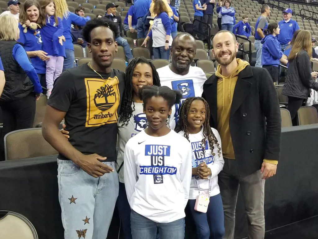 L-R: Arthur, Eva, Abigail, Patrick and Anna take picture with Mike Schmitz as they attend Adam's game in February 2022