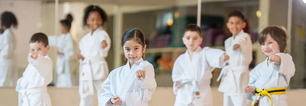 Kyu level karatekas standing in formation during their karate class. Most karate practitioners start their lessons by elementary level.