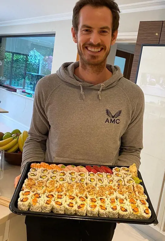 Andy wears AMC Hoodie while holding a platter of food.