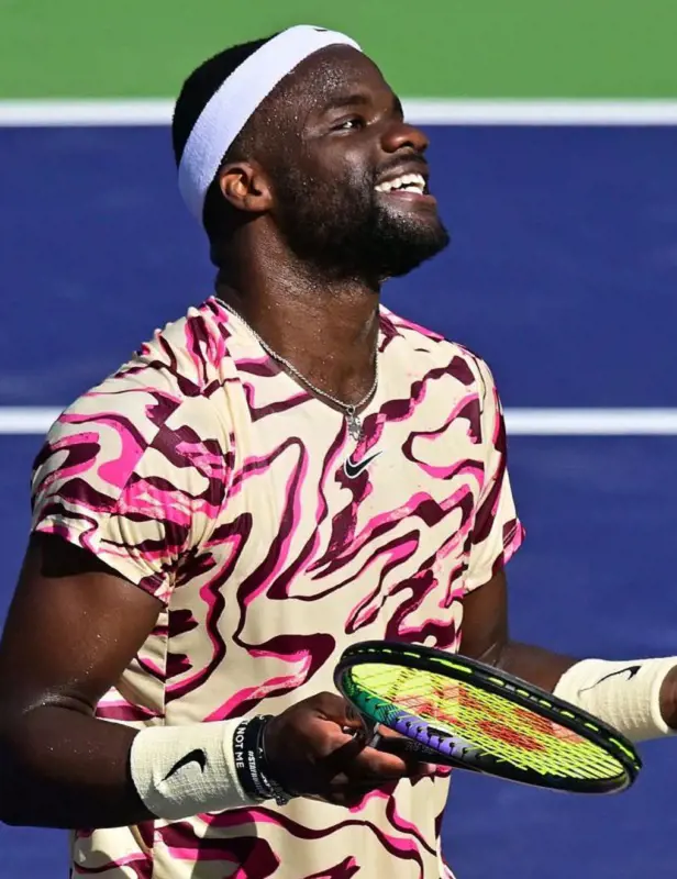 Frances Tiafoe gives a smile to audience during a tennis match.