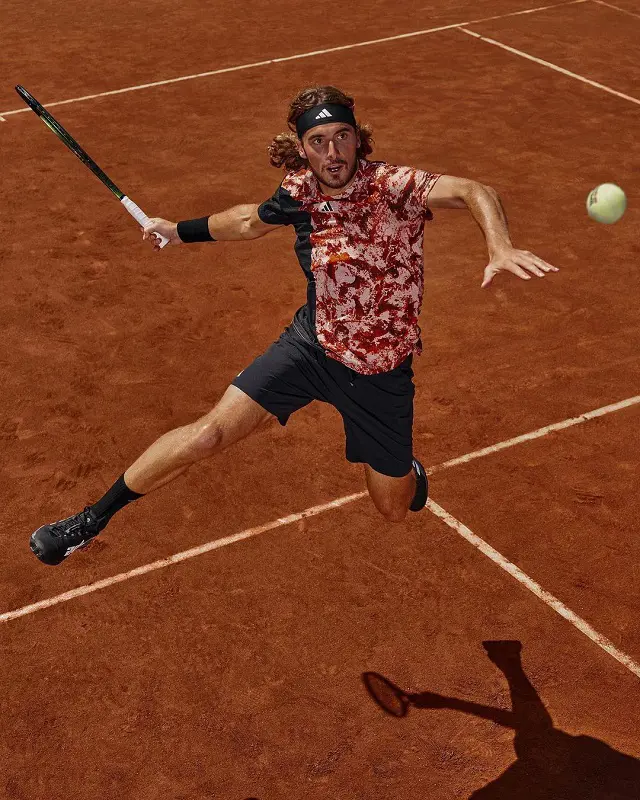 Stefanos Tsitsipas aims at the ball and makes a jump during a tennis match.