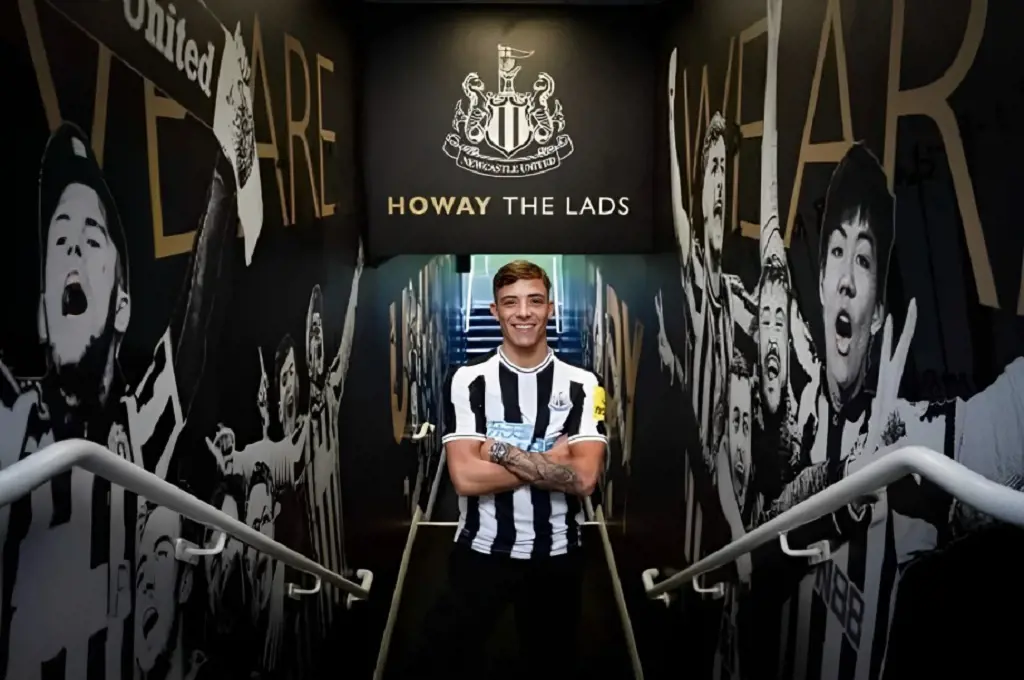Harrison Ashby poses in front of poster at St. James Park after joining Newcastle in January 2023