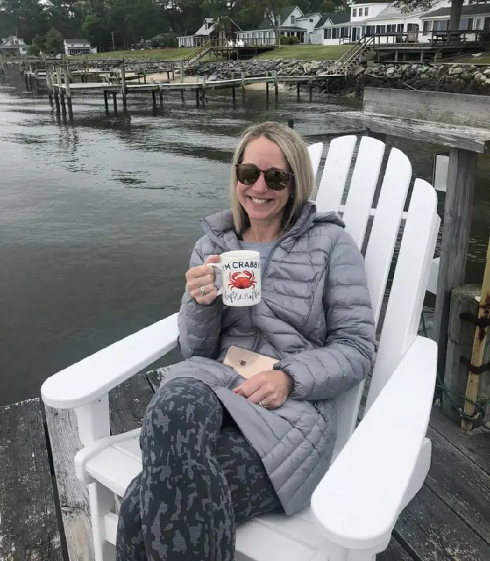 Jodie with a smile as she sits on chair sipping a hot coffee in a cold weather in May 2021