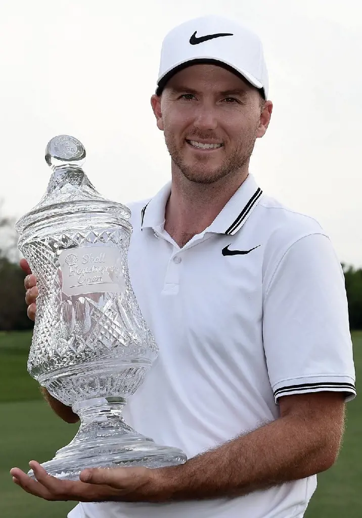 Russell donning Nike's golfing gears while holding Shell Houston Open trophy in 2017