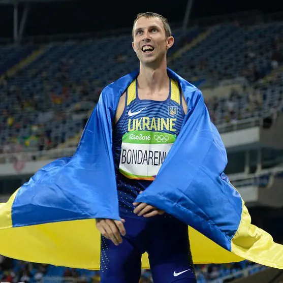 Bohdan Bondarenko drapes the Ukrainian flag as he gets a podium finish 