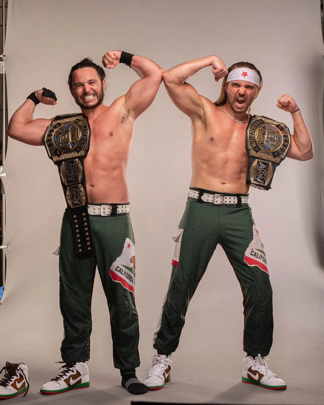 The Young Bucks striking pose with their AEW World Championship in June 2022